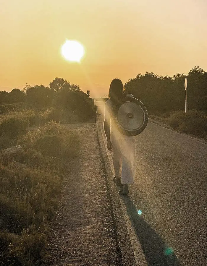 Cristian caminando con un gong al atardecer